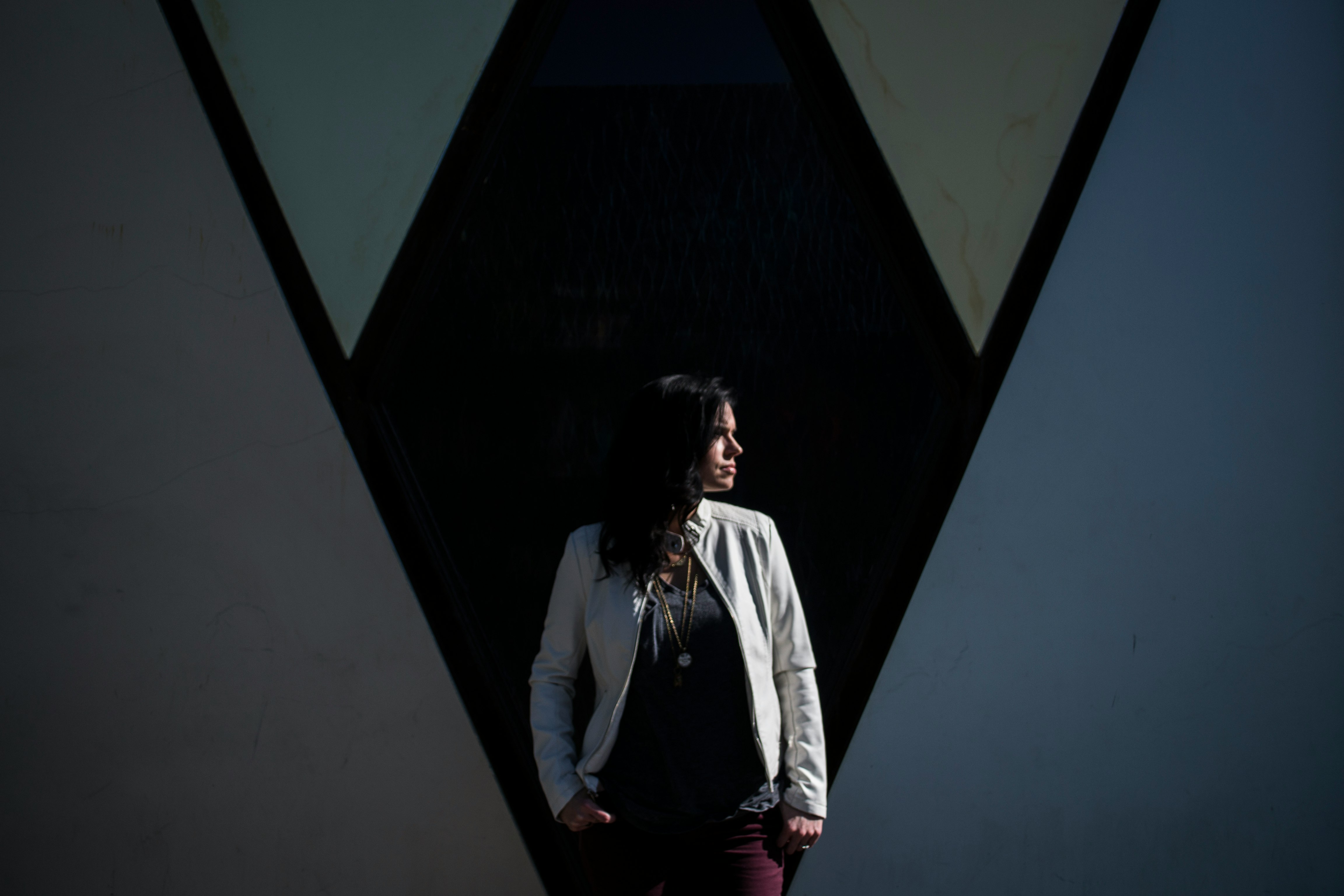 woman standing behind black wall while looking right side